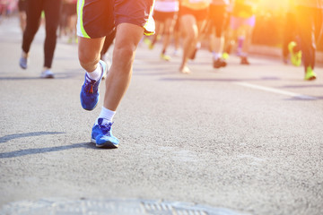 Fototapeta na wymiar marathon athletes legs running on city road