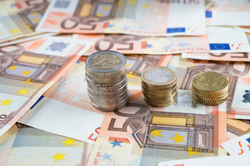 Pila di monete su banconote euro