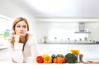 Young and beautiful housewife woman cooking in a kitchen