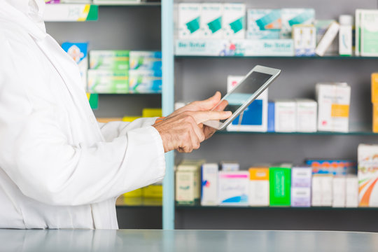 Handsome Pharmacist with Digital Tablet in a Drugstore