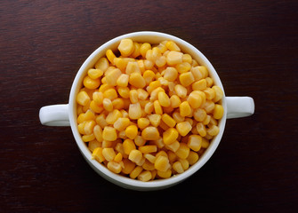 corn in bowl isolated on wooden background