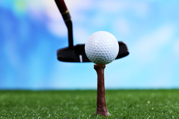 Golf ball and driver on green grass outdoor close up