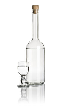 Spirituosenflasche und Klechglas gefüllt mit klarer Flüssigkeit