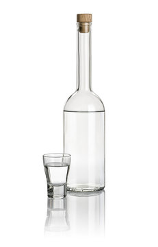 Spirituosenflasche und Shotglas gefüllt mit klarer Flüssigkeit