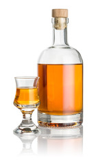 Flasche und Schnapsglas mit bernsteinfarbener Flüssigkeit