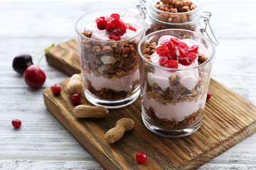 Healthy layered dessert with muesli and berries on table