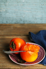 Ripe sweet persimmons, on wooden table