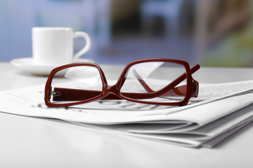 Glasses and newspapers, close-up