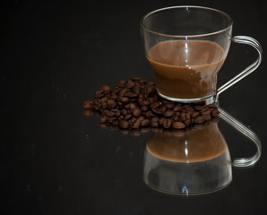 Coffee cup and coffee beans on a mirror