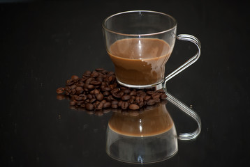 Coffee cup and coffee beans on a mirror