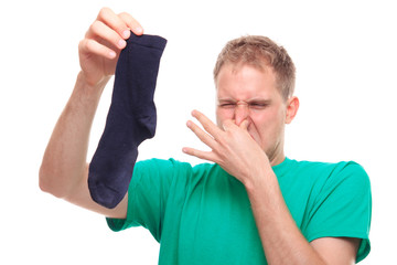 Man holding smelly socks and clogged nose