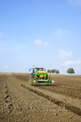 Fototapeta premium Acker´bau: Schlepper mit Drillmaschine bei der Herbstbestellung
