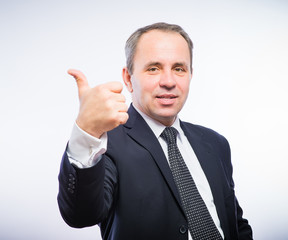 Happy smiling young business man with thumbs up gesture