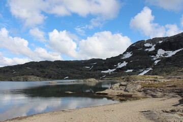 Mountains lake and blue sky with some clouds.
