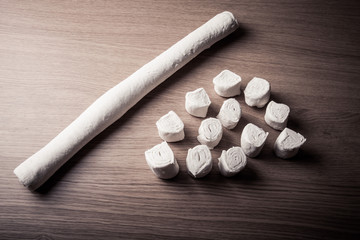 Pieces of dough on the wooden board. Toned