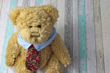Office teddy bear in shirt and tie on rustic background