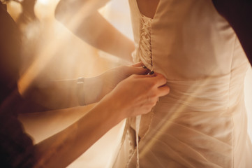 bride putting on wedding dress