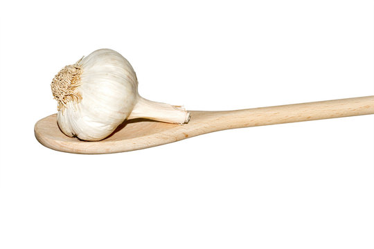 Garlic on a light wooden spoon