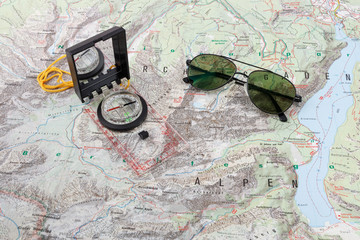 Compass and pilot sunglasses on a hiking map