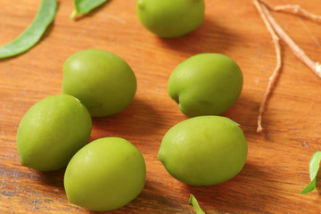 Green olives on wooden background