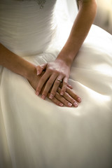 Fototapeta na wymiar portrait of brides hands lying on white wedding dress