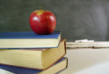 red apple and books with chalkboard