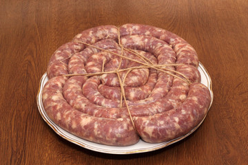 Ring of tied sausage on the white plate