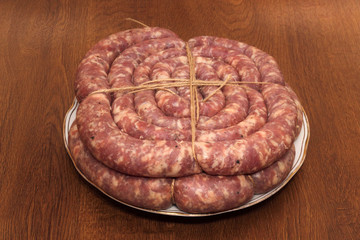 Obraz premium Two rings of tyied sausage on the white plate