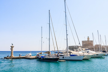 Fototapeta premium Ancient statue of a deer and a medieval lighthouse at the port o