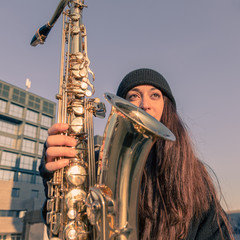 Beautiful young woman with her saxophone
