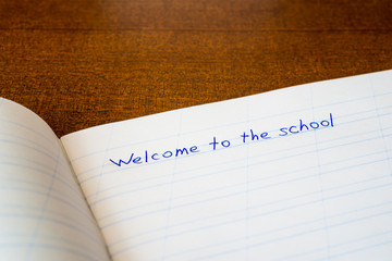 Welcome to the school, an exercise book on the wooden table