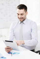 Naklejka premium businessman with tablet pc and files in office