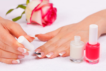 Obraz na płótnie Canvas Woman applying nail polish for perfect french manicure