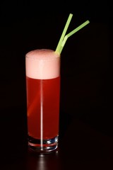 Glass of red sherbet with green straws