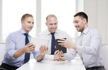 Fototapeta premium three smiling businessmen with tablet pc in office