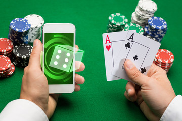 casino player with cards, smartphone and chips