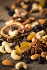 Close-up of nuts and dried fruits mix on wooden surface.