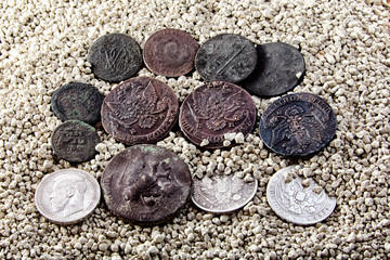 old coins on white sand