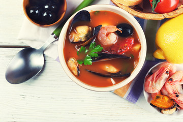 Tasty soup with shrimps, mussels, tomatoes and black olives in