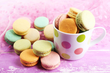 Assortment of gentle colorful macaroons in colorful mug