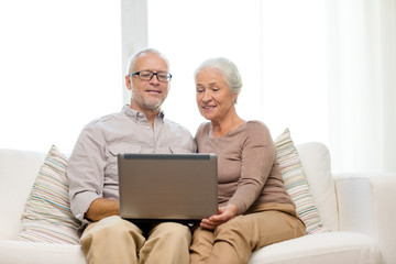 happy senior couple with laptop at home