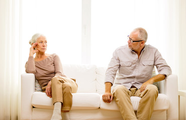 senior couple sitting on sofa at home