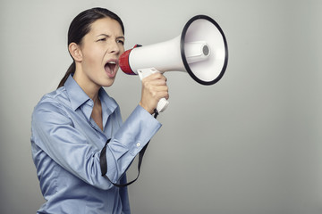 Junge Frau ruft laut mit einem Megafon