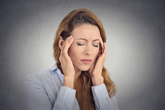 Young woman suffering from headache isolated grey background 