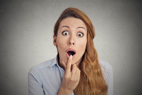 Surprised astonished woman with open mouth grey background 