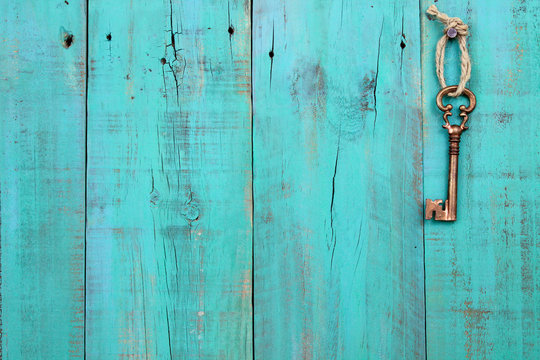 Skeleton key hanging on teal blue wood door