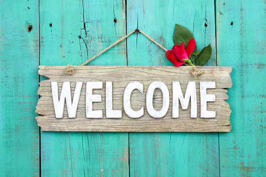 Welcome sign with rose hanging on door