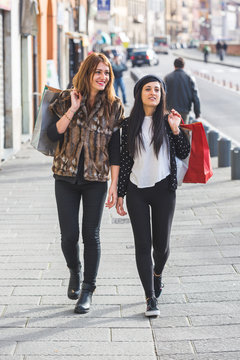 Happy Women Walking in the City with Shopping Bags