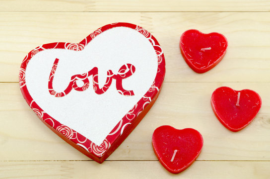 Heart shaped red candles and a box