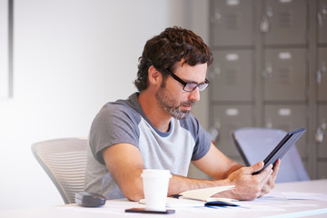 Casually Dressed Man Using Digital Tablet In Design Studio